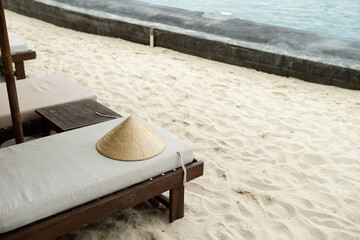 Vietnamese traditional hat 'Non La' on a beach chair by the beach