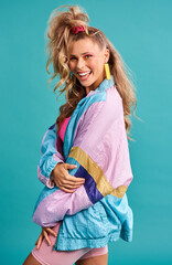80s fashion, retro style and woman portrait with vintage, neon and happiness in a studio. Blue background, female person and jacket of a model with workout, fitness and training outfit with a smile