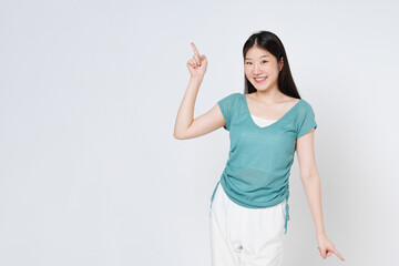 Happy young woman looking at camera and pointing up to copy space with smile face and happy isolated on white background.