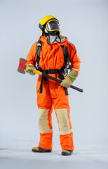 Vertical picture of firefighter holding iron axe while looking sideways with confidence on white background.