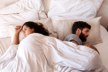Angry people, couple and fight in bed in the morning feeling frustrated from divorce talk. Marriage problem, conflict and fighting in a bedroom at home with anger argument and communication issue