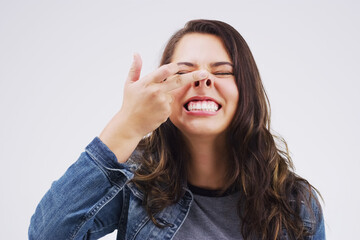 Smile, funny face and nose with a crazy woman in studio on a white background for carefree humor. Comic, comedy and showing nostrils with a weird young female person feeling playful while joking - obrazy, fototapety, plakaty