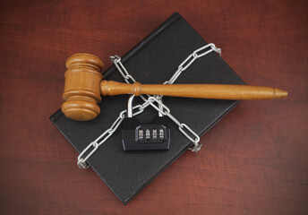 Censorship and information access in 2023. Wooden judge gavel on chained book and padlock with...