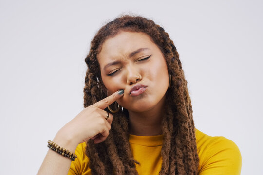 Finger, funny face and pout with a black woman joking in studio on a white background for humor. Comic, comedy and duckface with a pouting young female person feeling playful while having fun