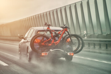 The car carries bikes. A vehicle traveling along a motorway with several bikes held on the rear...
