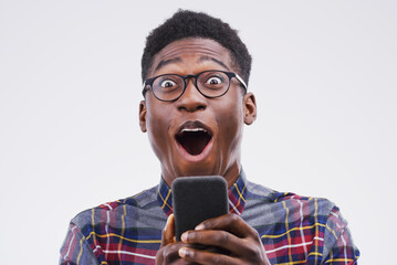 Black man, surprise and phone in shock for winning, prize or good news against a white studio...