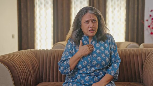 Aged Indian woman suffering from gastric and acidity problem