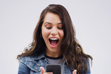 Woman, surprise and phone for winning, prize or good news against a white studio background. Shocked, surprised or excited female person reading on mobile smartphone of lottery winner in wow or bonus
