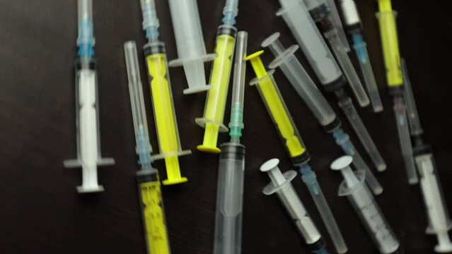 Many empty syringes on a rotating table. Treatment as prescribed by a doctor. Injections from diseases. Health care. Vaccines against viruses. Medicines for cancer