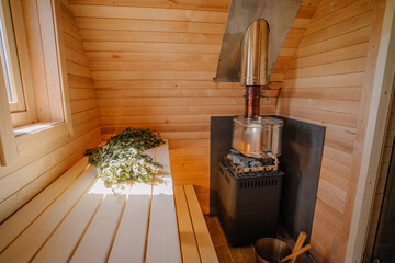 Wooden Igloo sauna from the inside, oven and sauna broom