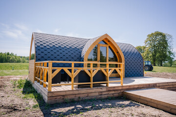 Igloo sauna made of wood with a boardwalk by the lake