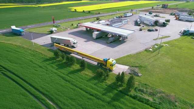 Truck at a gas station among canola fields. Truck transports crane beam