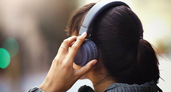 Woman with headphones in city, back view and listen to music, freedom and technology outdoor. Mockup space, podcast or radio streaming with female person in urban street and audio playlist