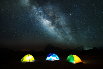 Amazing landscape of Milky Way in night sky over mountains with Camping Tent Picnic on top mountains, Adventure and outdoor travel concept