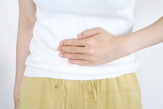 お腹を抑える手元　腹痛