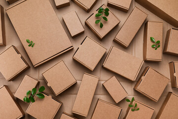 Heap of cardboard boxes from natural recyclable materials with green leaves sprout top view....