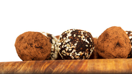 Energy balls in white bowl. Healthy raw dessert, vegetarian truffles, sugar free candies made of dates, hazelnuts, cocoa powder.