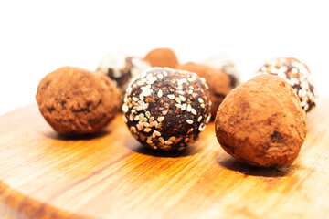Energy balls in white bowl. Healthy raw dessert, vegetarian truffles, sugar free candies made of dates, hazelnuts, cocoa powder.
