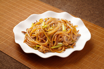 Stir-fried vermicelli with celery, a characteristic Chinese food, on a monochrome background