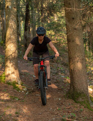 Female cyclist on her mountain bike riding through the hills on a sunny day.
