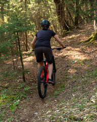 Female cyclist on her mountain bike riding through the hills on a sunny day.