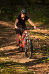 Female cyclist on her mountain bike riding through the hills on a sunny day.