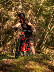 Female cyclist on her mountain bike riding through the hills on a sunny day.