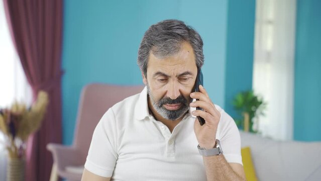 The grumpy old man gets angry at the phone call and hangs up.