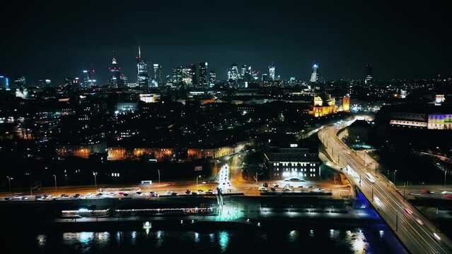 Night time lapse of Warsaw's Old Town viewed from the royal castle at a height. Beautiful architecture and city lights in Poland. Modern downtown financial center view after sunset, dusk cityscape, 