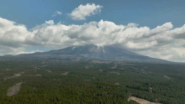 雲がかかる富士山とその麓の青木ヶ原樹海　空撮