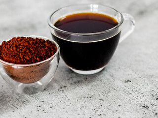 Closeup shot of balck coffee with powder in glass bowl.