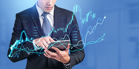 Businessman using tablet, forex diagrams and stock market data with candlesticks