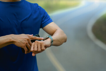 Cropped shot of male runner checking smartwatch to monitor training results. Technology health,...