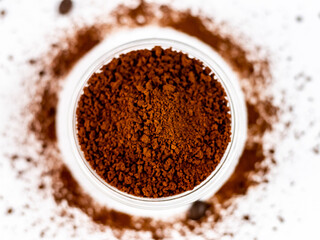 Extreme closeup shot of coffee powder in glass bowl with defocused circle on the background.
