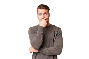 Young handsome caucasian man over isolated chroma key background having doubts and with confuse...