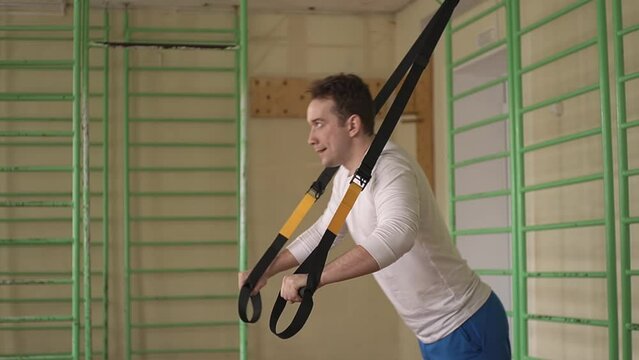 man doing workout with fitness loops in the gym. workout with fitness loops. High quality Full HD video recording