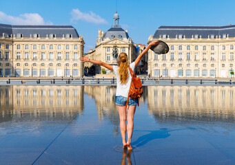 Woman traveler in France- Bordeaux city,  Bourse square with water mirror- Gironde, Nouvelle aquitaine - obrazy, fototapety, plakaty