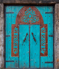 Old turquoise wooden door with decorations