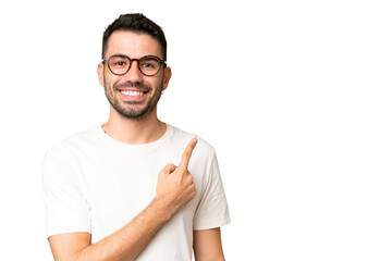 Young handsome caucasian man over isolated chroma key background pointing to the side to present a product