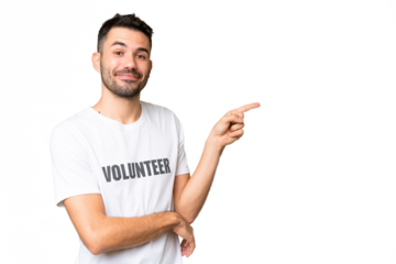 Young volunteer caucasian man over isolated chroma key background pointing finger to the side
