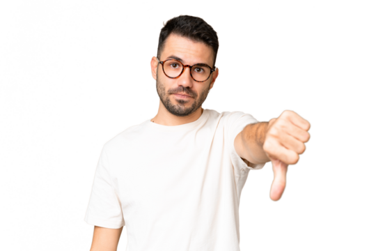 Young handsome caucasian man over isolated chroma key background showing thumb down with negative expression