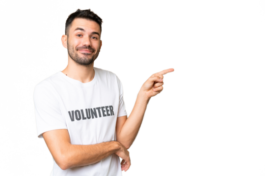 Young volunteer caucasian man over isolated chroma key background pointing finger to the side