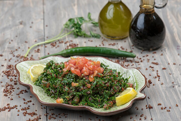 Tabbouleh salad, plate, Traditional middle eastern or arab dish. Levantine vegetarian salad with parsley, mint, bulgur, tomato. Part of middle eastern meze. lebanese salad of Tabbouleh 
