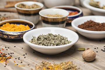 large collection of different spices and herbs on a wooden table 