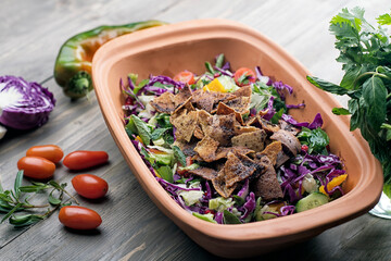 fattoush Salad , Lebanese salad, Fattouch with veggies on a wooden table 
