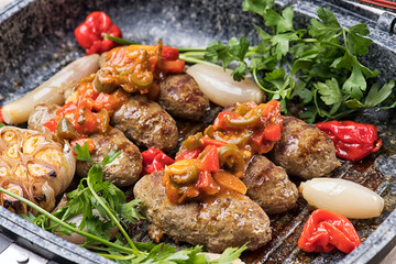 Kofta with tomato sauce, Cooked tomato and cooked potato garnished with pine seeds and mint isolated on white background 