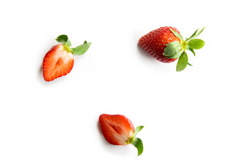 Strawberries on a white background. One whole berry and two halves of juicy fruit. Composition in the style of flat lay.