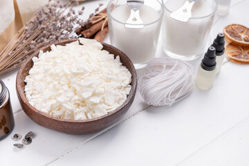 Set for crafting candle on wooden background. Eco soy wax and candle making tools top view, flat lay