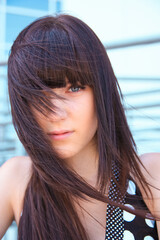 beautiful young brunette woman on the background of a modern building