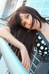 beautiful young brunette woman on the background of a modern building